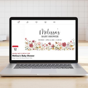 May include: A laptop screen displaying a baby shower invitation with a floral border. The invitation reads "Melissa's Baby Shower" and includes the date and time: "Saturday, April 12, 20XX | 11:00 AM".