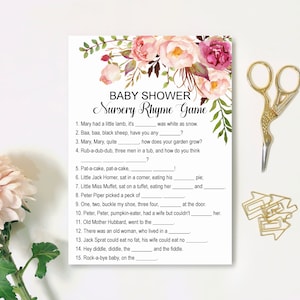 Op de afbeelding: Een roze en groene baby shower-spelkaart met de titel "Nursery Rhyme Game". De kaart bevat 15 rijm-invulvragen.