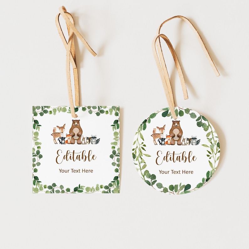 以下が含まれることがあります： 森の動物をテーマにした印刷可能なタグが2つ。1つは正方形、もう1つは丸形。どちらのタグにも、鹿、キツネ、アライグマ、フクロウなどの他の森の動物に囲まれた茶色のクマが描かれています。タグは緑の葉と「Editable Your Text Here」というテキストで飾られています。