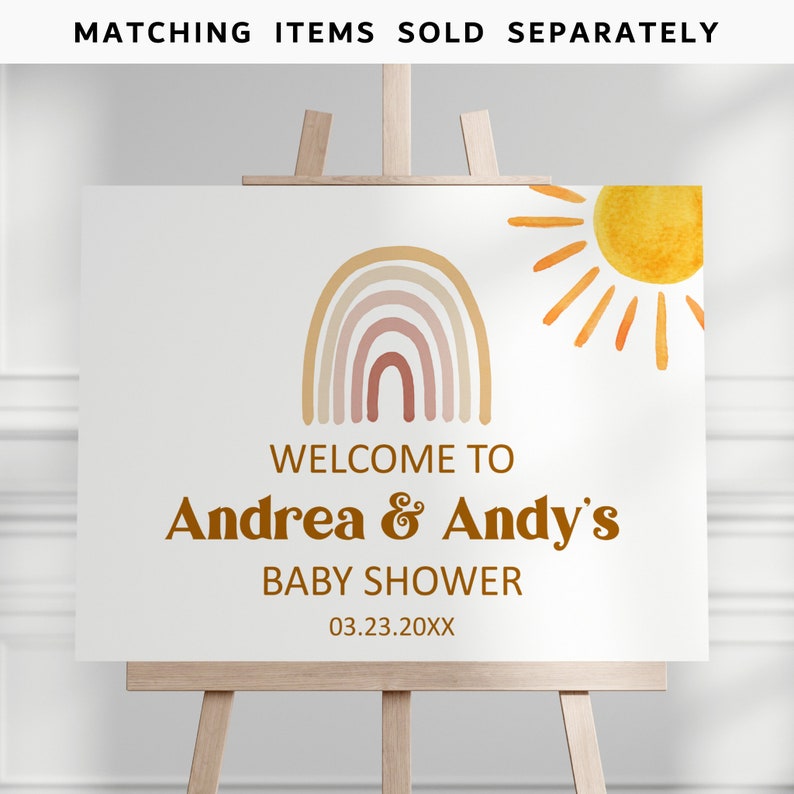 May include: Welcome to Andrea & Andy's Baby Shower sign with a rainbow and sun illustration. The sign is white with brown text and a date of 03.23.20XX.
