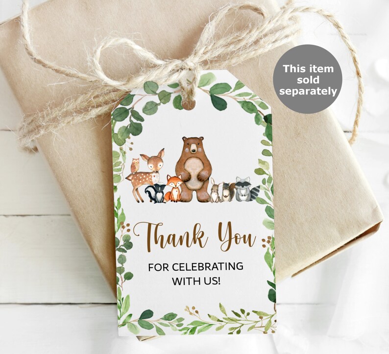 May include: Thank you for celebrating with us!  A white tag with a green leafy border features a brown bear and other woodland animals.  The tag is tied with twine.