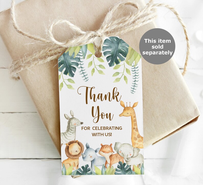 May include: A gift tag with a jungle theme, featuring a giraffe, zebra, lion, rhino, fox, and elephant. The tag says "Thank You for Celebrating with Us!" and is tied to a wrapped gift with twine.