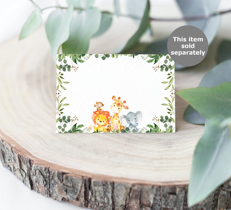 May include: A blank white card with a green leafy border. The card features a watercolor illustration of a lion, giraffe, and elephant. The text "This item sold separately" is in the top right corner of the image.
