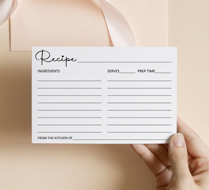 May include: A blank white recipe card with the word "Recipe" written in black cursive at the top. The card has lines for writing down ingredients, servings, prep time, and from the kitchen of.