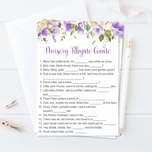 Puede incluir: Una tarjeta imprimible del juego de rimas infantiles con un dise&ntilde;o floral en morado y blanco. El texto "Nursery Rhyme Game" est&aacute; en la parte superior, con l&iacute;neas para completar las rimas infantiles cl&aacute;sicas. Un l&aacute;piz y pinzas para la ropa est&aacute;n en la imagen.