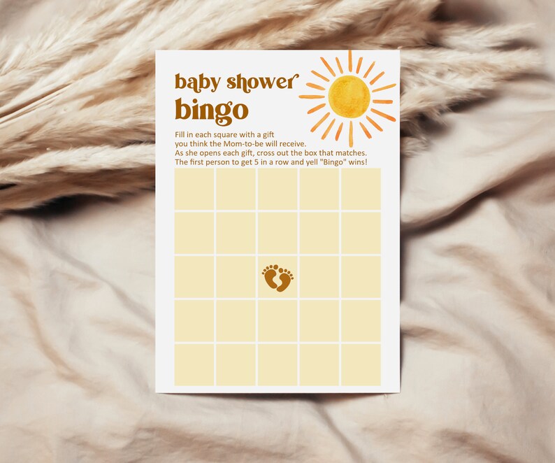 K&ouml;nnte beinhalten: Eine gelbe und braune Babyparty-Bingo-Karte mit einem Sonnen-Motiv und dem Text "baby shower bingo". Die Karte hat ein Raster mit Feldern, in einem der Felder befindet sich ein Fu&szlig;abdruck-Motiv. Der Text unter dem Raster lautet "F&uuml;lle jedes Feld mit einem Geschenk, von dem du glaubst, dass die werdende Mutter es erhalten wird. Wenn sie jedes Geschenk &ouml;ffnet, streiche das entsprechende Feld durch. Die erste Person, die 5 in einer Reihe erh&auml;lt und "Bingo" ruft, gewinnt!"