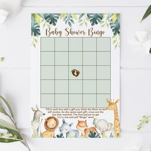 Puede incluir: Una tarjeta de bingo de baby shower verde y blanca con un tema de animales de la selva. La tarjeta tiene un espacio libre con un icono de huella marr&oacute;n. El texto "Baby Shower Bingo" est&aacute; en la parte superior de la tarjeta. La parte inferior de la tarjeta tiene instrucciones para jugar al juego.