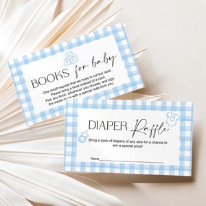 May include: Two baby shower invitation cards with a blue gingham border. The top card reads "Books for baby" and requests a book instead of a card. The bottom card reads "Diaper Raffle" and asks guests to bring diapers.