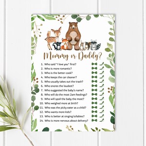 May include: A printable game card with a woodland animal theme. The card has a brown bear, a deer, a fox, a raccoon, and an owl. The text on the card reads "Mommy or Daddy?" and includes a list of 14 questions about the parents-to-be.