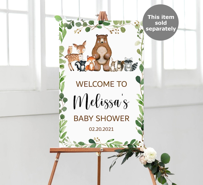 May include: Welcome to Melissa's Baby Shower sign with a woodland theme. The sign features a brown bear, a deer, a fox, a raccoon, and other woodland animals. The sign is decorated with green leaves and a white background.