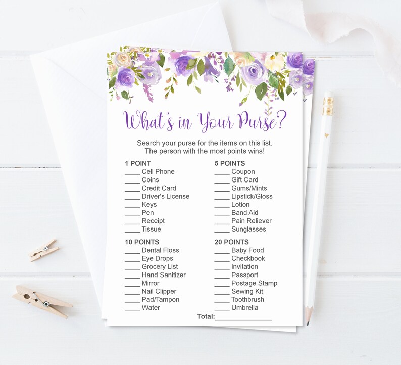 Puede incluir: Tarjeta de juego "&iquest;Qu&eacute; hay en tu bolso?" con un dise&ntilde;o floral en morado y blanco. La tarjeta de juego incluye una lista de elementos con valores en puntos. Un l&aacute;piz y pinzas para la ropa est&aacute;n en el fondo.