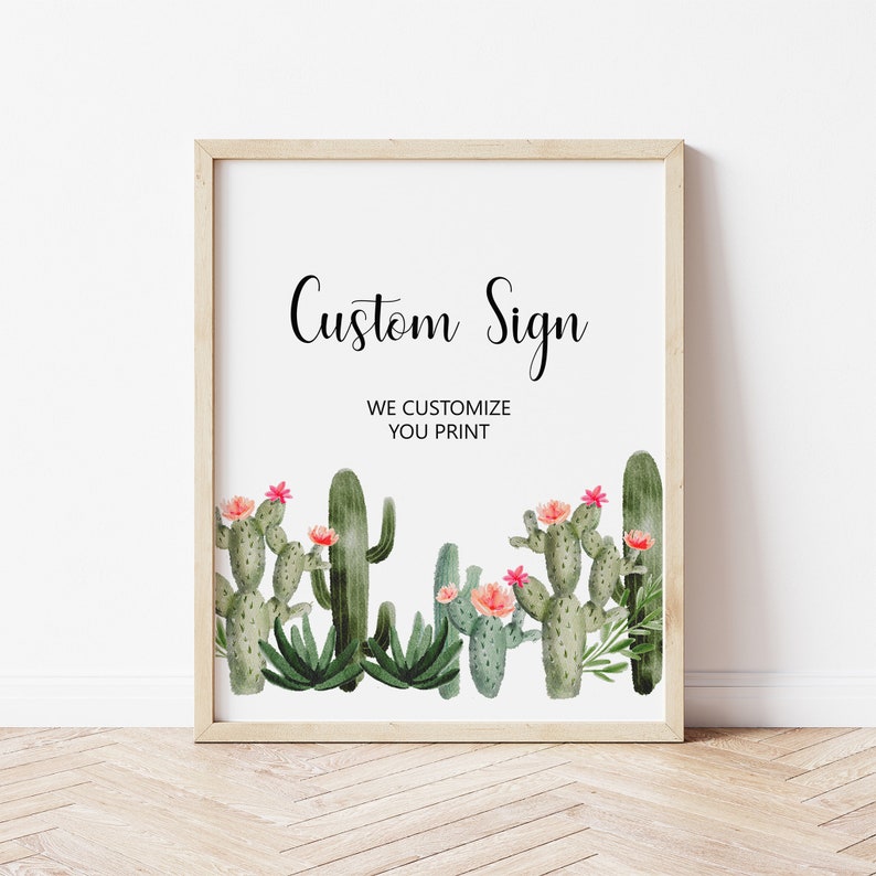 May include: A framed sign with a white background and a green cactus illustration. The sign says 'Custom Sign' and 'We Customize You Print'.