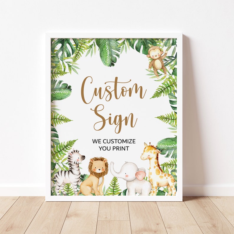 May include: A white framed sign with a green jungle theme. The sign has the text 'Custom Sign' in gold lettering. The sign also has the text 'We Customize You Print'. The sign is decorated with green leaves, a monkey, a zebra, a lion, an elephant, and a giraffe.