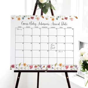 K&ouml;nnte beinhalten: Ein wei&szlig;er Kalender mit floralem Rand, beschriftet mit "Erraten Sie das Ankunftsdatum von Baby Johnson". Der Kalender ist f&uuml;r Februar und M&auml;rz, wobei der Geburtstermin auf den 22. Februar f&auml;llt.