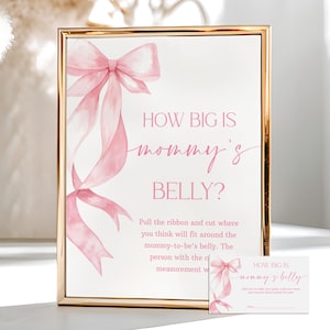 Può includere: Un cartello incorniciato con la scritta "HOW BIG IS mommy's BELLY?" in corsivo rosa. Un disegno di nastro rosa adorna il lato sinistro. È presente anche una carta più piccola con lo stesso design, che suggerisce un gioco per il baby shower.