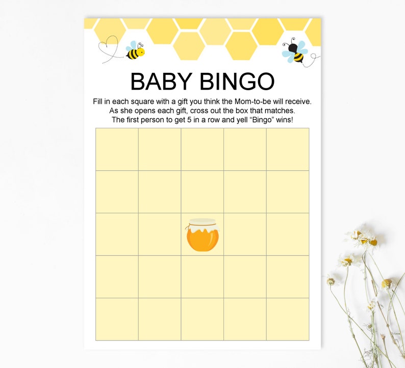May include: A yellow and white baby shower bingo card with a honeycomb pattern and bee illustrations. The card has a title that says "Baby Bingo" and instructions to fill in each square with a gift the mom-to-be will receive. The first person to get 5 in a row and yell "Bingo" wins!