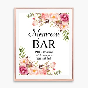 Op de afbeelding: Een printbaar bord met roze en bordeauxrode bloemenillustraties. Het bord zegt "Mom-osa Bar" en bevat instructies: "GIET de bubbels in, VOEG wat sap toe, TOP af met fruit".