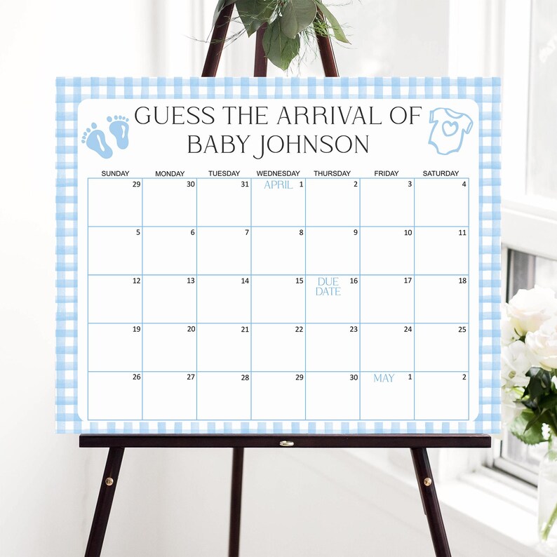 May include: A baby shower calendar on an easel, featuring a blue gingham border. The calendar reads "Guess the Arrival of Baby Johnson" and includes a calendar grid with the due date marked on April 15th.