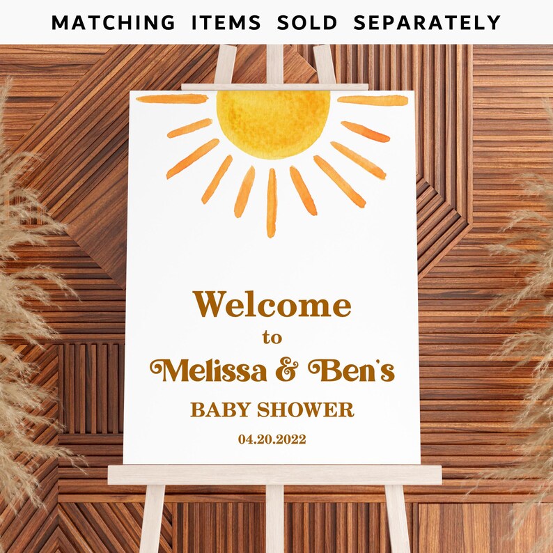 May include: Welcome to Melissa & Ben's Baby Shower sign with a yellow sun illustration and the date 04.20.2022.