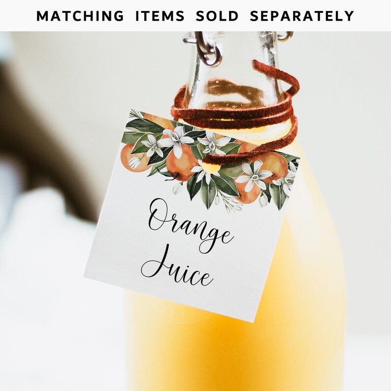 May include: A white square tag with a watercolor illustration of orange blossoms and fruit. The tag is tied to a glass bottle of orange juice. The tag reads "Orange Juice" in black cursive font.