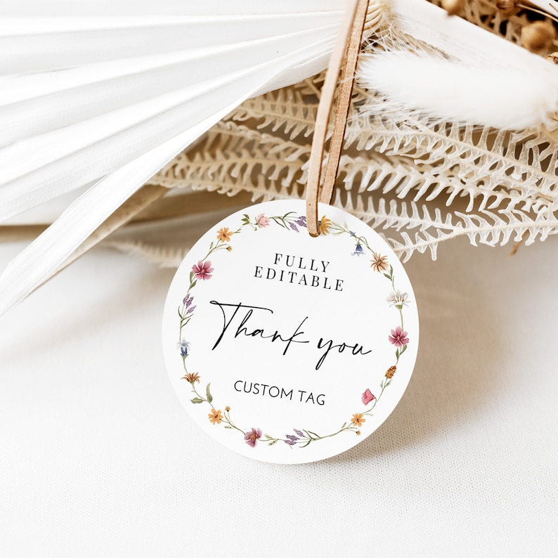 Pode incluir: Uma etiqueta redonda branca de agradecimento com uma borda de coroa de flores. A etiqueta diz "FULLY EDITABLE" e "Thank you" em uma fonte de escrita. Tamb&eacute;m diz "CUSTOM TAG" na parte inferior.