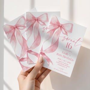 May include: Three white Sweet 16 birthday invitations with a watercolor pink bow and ribbon design. The invitations include the text "sweet 16" and event details. The invitations are held in a hand.