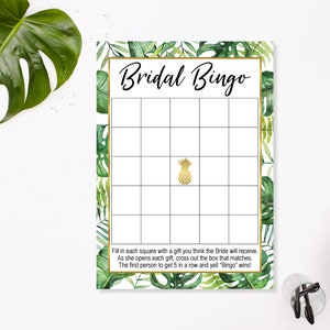 May include: A printable bridal shower bingo card with a tropical theme. The card has a green and gold color scheme with a pineapple in the center. The text "Bridal Bingo" is at the top of the card. The instructions are at the bottom of the card.
