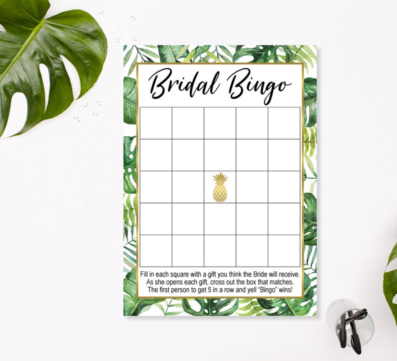 May include: A printable bridal shower bingo card with a tropical theme. The card has a green and gold color scheme with a pineapple in the center. The text "Bridal Bingo" is at the top of the card. The instructions are at the bottom of the card.