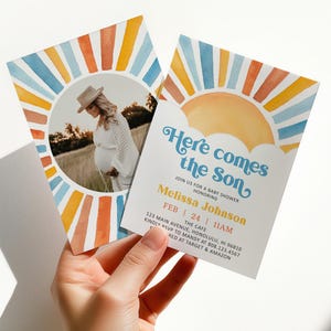 May include: Baby shower invitation with a watercolor sun design in blue, orange, and yellow. The invitation includes a photo of a pregnant person and the text "Here comes the Son" with event details.