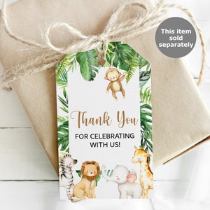 May include: A white thank you tag with a jungle theme. The tag features a monkey, zebra, lion, elephant, and giraffe. The text on the tag reads "Thank You for Celebrating with Us!"