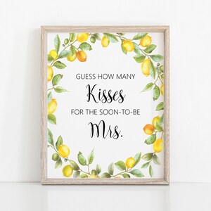 Op de afbeelding: Een wit printbaar bord met een rand van een citroenkrans. De tekst luidt "Raad hoeveel kussen voor de aanstaande mevrouw."