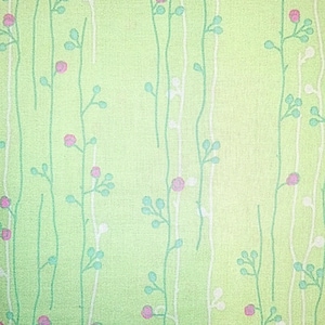 May include: A green fabric with a repeating pattern of white and green stems with pink flowers.
