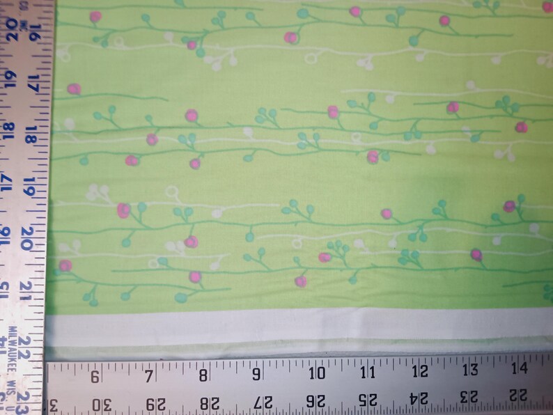 May include: Green fabric with a white and light green floral pattern. The fabric has a subtle sheen and a soft texture.