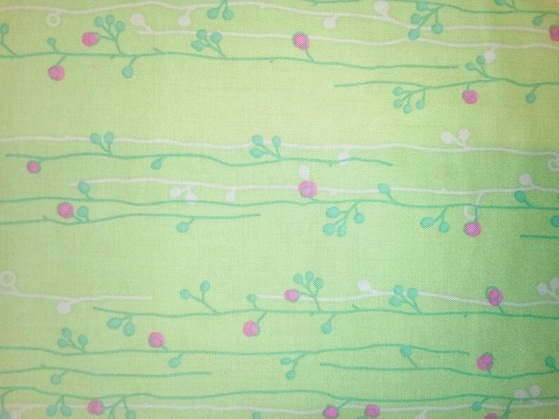 May include: A green fabric with a white and light green floral pattern. The pattern features small pink flowers and leaves.