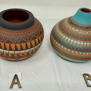 May include: Two handcrafted ceramic vases. One is round with a dark rim and intricate geometric patterns in brown, orange, and white. The other is a bulbous shape with a turquoise top and similar patterns in brown and teal.