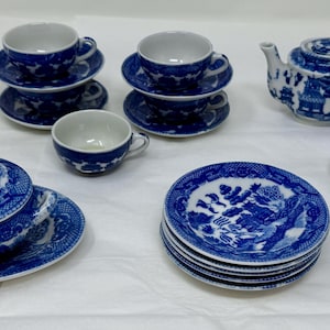 Può includere: Un set di miniature in porcellana blu e bianca, tra cui tazze, piattini, una teiera, una zuccheriera, un piatto da portata con coperchio e piattini. Il set presenta un design tradizionale dettagliato.