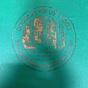 May include: A close-up of a teal-colored book cover with a circular emblem. The emblem features the text "Douglas Fir Use Book" and "Structural Data and Design Tables." The text "West Coast Lumbermen's Association" is also visible.