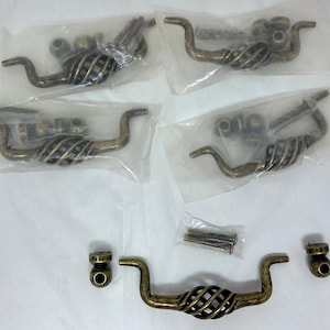 May include: Five antique brass cabinet pulls with a twisted design. Each pull comes with screws for installation.