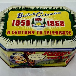 Puede incluir: Caja de lata vintage con tapa amarilla y verde, con la inscripción "British Columbia 1858-1958 A Century to Celebrate". La caja también presenta una ilustración de dibujos animados y las palabras "Riley's Toffee".