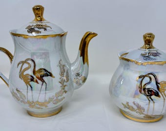 Tetera o azucarero vintage de porcelana iridiscente dorada con diseño de flamencos. Decoración de mediados de siglo.