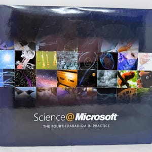 Op de afbeelding: Een donkerblauwe boekomslag met de titel "Science @ Microsoft" en de ondertitel "The Fourth Paradigm in Practice". De omslag toont een raster van kleurrijke wetenschappelijke afbeeldingen, waaronder cellen, de ruimte en medische scans.