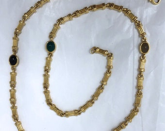 Colar longo dourado com corrente esculpida em pedra semipreciosa e um escaravelho.