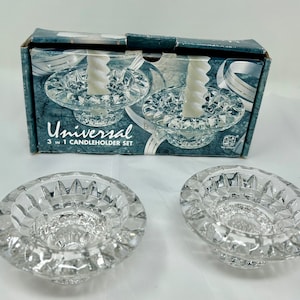 May include: A set of three clear glass candle holders with a crystal-like design. The candle holders are packaged in a box that says "Universal 3 in 1 Candleholder Set".