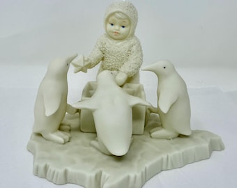 スノーベイビーズの雪に覆われた子供とプレゼントの磁器の置物