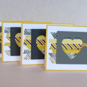 Conjunto de cartões comemorativos. Conjunto com 4 cartões para todas as ocasiões. Cartões artesanais em formato de coração tridimensional e fita washi. Cartões em branco. Barbante de confeiteiro. Cinza e amarelo.