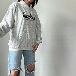 May include: A gray hooded sweatshirt with a Mickey Mouse graphic and the text "Mickey America's Favorite".