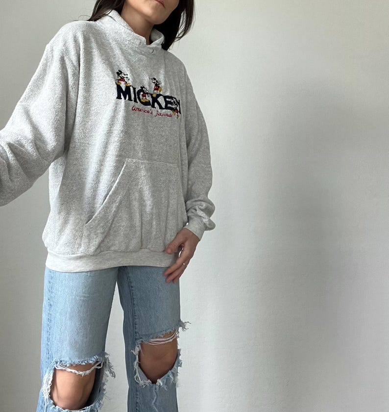 May include: A gray hooded sweatshirt with a Mickey Mouse graphic and the text "Mickey America's Favorite".