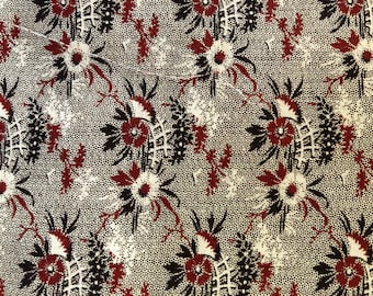 May include: Close-up of a fabric with a repeating floral pattern. The design features burgundy, black, and white flowers and foliage on a dotted, off-white background. The pattern has a vintage aesthetic.