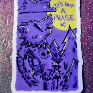 May include: A purple sticker with a cartoon wolf howling at the moon. The moon is yellow with the text "It's not a phase." The wolf is in a forest with trees and a cloud in the background.