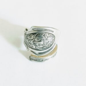 May include: A silver ring made from a repurposed spoon with an ornate floral design.